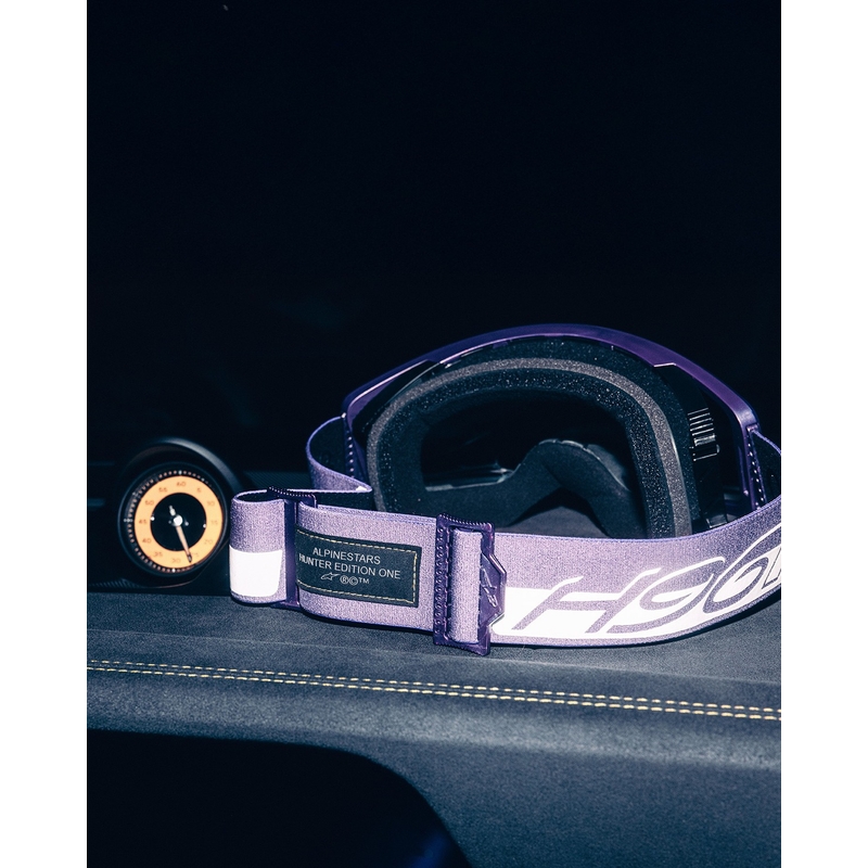 Alpinestars Supertech Vision Hunta96 XXV motocross-lasit violetti ja valkoinen peilillä ja hopeisella pleksillä.